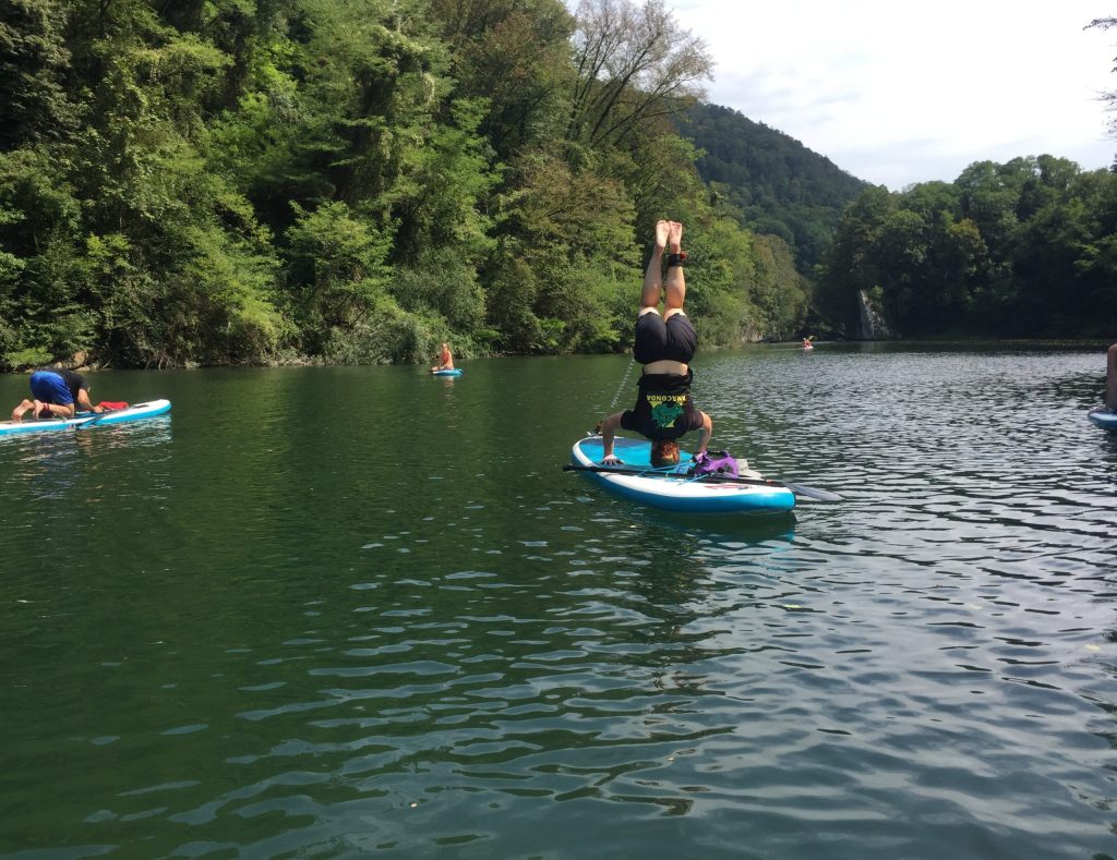 Ali doing a headstand on a paddleboard